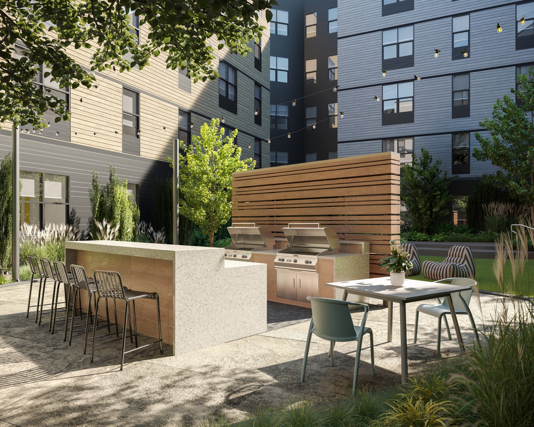 Grilling stations with counter seating and table in the courtyard of The Marshall Binghamton